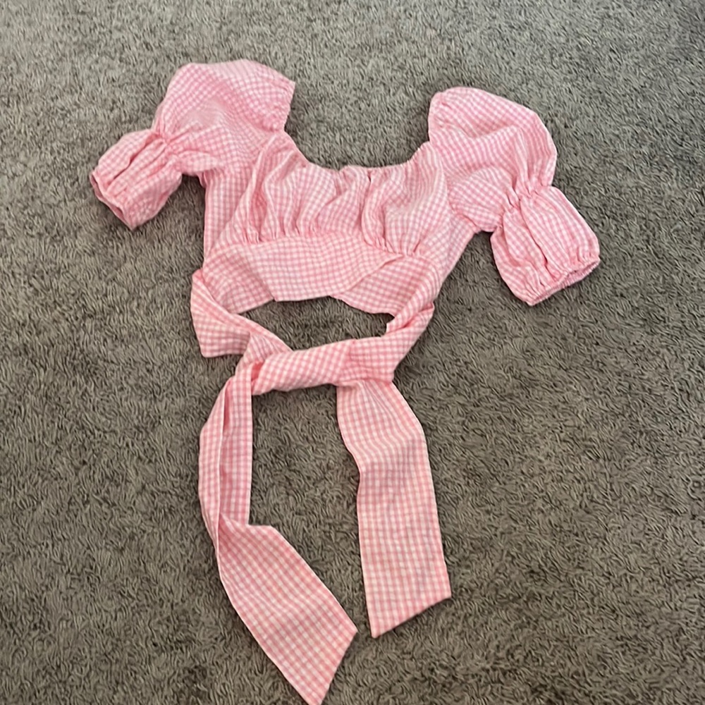 Pink gingham cropped top with puffed sleeves and a tie waist.
